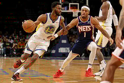 Nov 16, 2021; Brooklyn, New York, USA; Golden State Warriors forward Andrew Wiggins (22) drives around Brooklyn Nets forward Bruce Brown (1) during the first quarter at Barclays Center. Mandatory Credit: Brad Penner-USA TODAY Sports