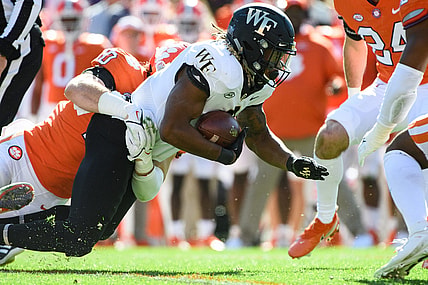 Nov 20, 2021; Clemson, South Carolina, USA;  Wake Forest running back Christian Turner (0) is tackled by Clemson linebacker Baylon Spector (10) during their game at Memorial Stadium. Mandatory Credit: Josh Morgan-USA TODAY Sports
