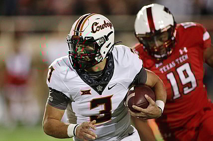 Nov 20, 2021; Lubbock, Texas, USA;  Oklahoma State Cowboys quarterback Spencer Sanders (3) runs the ball against Texas Tech Red Raiders defensive lineman Tyree Wilson (19) in the first half at Jones AT&T Stadium. Mandatory Credit: Michael C. Johnson-USA TODAY Sports