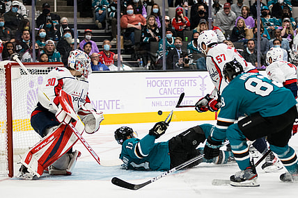 Nov 20, 2021; San Jose, California, USA;  San Jose Sharks center Andrew Cogliano (11) falls as Washington Capitals goaltender Ilya Samsonov (30) and defenseman Trevor van Riemsdyk (57) defend during the second period at SAP Center at San Jose. Mandatory Credit: John Hefti-USA TODAY Sports