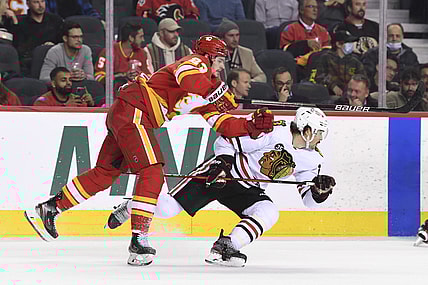 Nov 23, 2021; Calgary, Alberta, CAN; Calgary Flames forward Sean Monahan (23) collides with Chicago Blackhawks forward Ryan Carpenter (22) during the second period at Scotiabank Saddledome. Mandatory Credit: Candice Ward-USA TODAY Sports