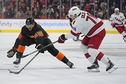 Nov 26, 2021; Philadelphia, Pennsylvania, USA; Philadelphia Flyers center Zack MacEwen (17) reaches for the puck against Carolina Hurricanes defenseman Brady Skjei (76) in the first period at the Wells Fargo Center. Mandatory Credit: Mitchell Leff-USA TODAY Sports