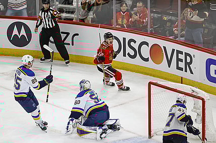 Nov 26, 2021; Chicago, Illinois, USA; Chicago Blackhawks left wing Alex DeBrincat (12) celebrates after scoring a goal in overtime against the St. Louis Blues at United Center. Mandatory Credit: Kamil Krzaczynski-USA TODAY Sports