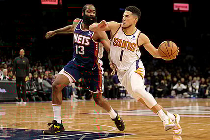 Nov 27, 2021; Brooklyn, New York, USA; Phoenix Suns guard Devin Booker (1) drives to the basket around Brooklyn Nets guard James Harden (13) during the first quarter at Barclays Center. Mandatory Credit: Brad Penner-USA TODAY Sports