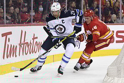 Nov 27, 2021; Calgary, Alberta, CAN; Winnipeg Jets forward Blake Wheeler (26) battles for the puck with Calgary Flames defenseman Nikita Zadorov (16) during the first period at Scotiabank Saddledome. Mandatory Credit: Candice Ward-USA TODAY Sports