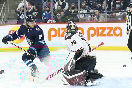 Nov 29, 2021; Winnipeg, Manitoba, CAN;  Winnipeg Jets forward Kyle Connor (81) watches the puck go past Arizona Coyotes goalie Kyle Capobianco (70) during the second period at Canada Life Centre. Mandatory Credit: Terrence Lee-USA TODAY Sports