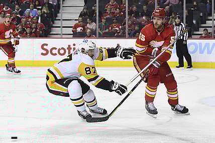 Nov 29, 2021; Calgary, Alberta, CAN; Calgary Flames defenseman Noah Hanifin (55) defends against Pittsburgh Penguins forward Sidney Crosby (87) during the second period at Scotiabank Saddledome. Mandatory Credit: Candice Ward-USA TODAY Sports