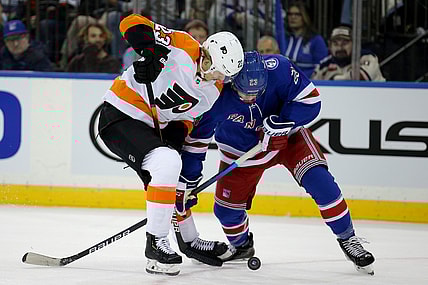 Dec 1, 2021; New York, New York, USA; Philadelphia Flyers left wing Oskar Lindblom (23) and New York Rangers defenseman Adam Fox (23) fight for the puck during the first period at Madison Square Garden. Mandatory Credit: Brad Penner-USA TODAY Sports