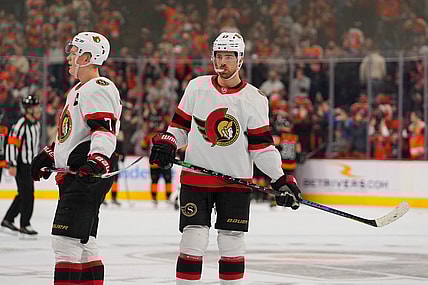 Dec 18, 2021; Philadelphia, Pennsylvania, USA; Ottawa Senators left wing Brady Tkachuk (7) and left wing Zach Sanford (13) react after losing to the Philadelphia Flyers in overtime at the Wells Fargo Center. Mandatory Credit: Mitchell Leff-USA TODAY Sports