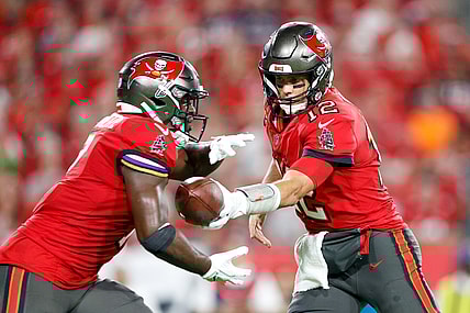 Dec 19, 2021; Tampa, Florida, USA;  Tampa Bay Buccaneers quarterback Tom Brady (12) hands off to running back Leonard Fournette (7) in the second quarter against the New Orleans Saints at Raymond James Stadium. Mandatory Credit: Nathan Ray Seebeck-USA TODAY Sports