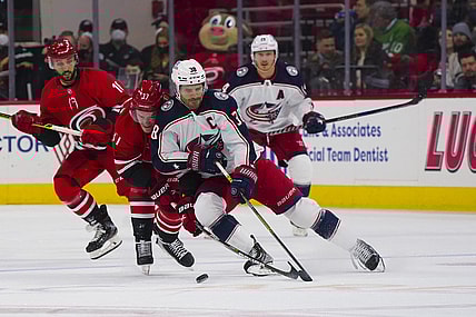 Jan 13, 2022; Raleigh, North Carolina, USA; Columbus Blue Jackets center Boone Jenner (38) handles the puck against Carolina Hurricanes right wing Andrei Svechnikov (37) during the first period at PNC Arena. Mandatory Credit: James Guillory-USA TODAY Sports