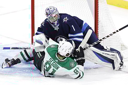 Nov 2, 2021; Winnipeg, Manitoba, CAN;  Dallas Stars center Tyler Seguin (91) collides with Winnipeg Jets goaltender Eric Comrie (1) in the third period at Canada Life Centre. Mandatory Credit: James Carey Lauder-USA TODAY Sports