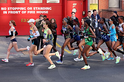 Nov 7, 2021; New York, New York, USA;  Elite runners go by a fire house in Brooklyn during the New York City Marathon.  Mandatory Credit: Kevin R. Wexler-USA TODAY Sports