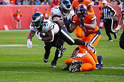 Nov 14, 2021; Denver, Colorado, USA; Philadelphia Eagles running back Boston Scott (35) dives over Denver Broncos safety Kareem Jackson (22) in the first quarter at Empower Field at Mile High. Mandatory Credit: Ron Chenoy-USA TODAY Sports