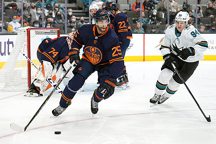 Feb 14, 2022; San Jose, California, USA; Edmonton Oilers defenseman Darnell Nurse (25) skates with the puck while being pursued by San Jose Sharks left wing Alexander Barabanov (94) during the second period at SAP Center at San Jose. Mandatory Credit: Darren Yamashita-USA TODAY Sports