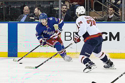 Feb 24, 2022; New York, New York, USA; New York Rangers defenseman Adam Fox (23) controls the puck as Washington Capitals defenseman John Carlson (74) defends during the first period at Madison Square Garden. Mandatory Credit: Vincent Carchietta-USA TODAY Sports