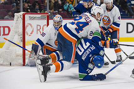 Feb 9, 2022; Vancouver, British Columbia, CAN; New York Islanders defenseman Scott Mayfield (24) checks Vancouver Canucks forward Tanner Pearson (70) in the third period at Rogers Arena. New York won 6-3. Mandatory Credit: Bob Frid-USA TODAY Sports