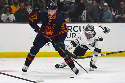 Feb 15, 2022; Los Angeles, California, USA; Edmonton Oilers center Connor McDavid (97) and LA Kings center Anze Kopitar (11) battle for the puck in the first period at Crypto.com Arena. Mandatory Credit: Kirby Lee-USA TODAY Sports