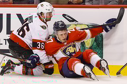 Mar 3, 2022; Sunrise, Florida, USA; Ottawa Senators center Colin White (36) and Florida Panthers center Eetu Luostarinen (27) collide against the boards during the second period at FLA Live Arena. Mandatory Credit: Sam Navarro-USA TODAY Sports