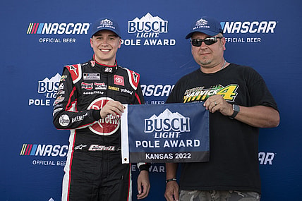 May 14, 2022; Kansas City, Kansas, USA; NASCAR Cup Series driver Christopher Bell (left) reacts after securing the pole position during AdventHealth 400 qualifying at Kansas Speedway. Mandatory Credit: Amy Kontras-USA TODAY Sports