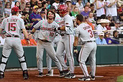Jun 21, 2022; Omaha, NE, USA;  Arkansas Razorbacks right fielder Chris Lanzilli (18) greets catcher Dylan Leach (15) and first baseman Peyton Stovall (10)  and left fielder Zack Gregory (3) after hitting a home run against the Auburn Tigers in the fourth inning at Charles Schwab Field. Mandatory Credit: Steven Branscombe-USA TODAY Sports