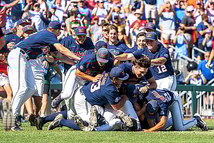 Jun 26, 2022; Omaha, NE, USA; Ole Miss Rebels players dogpile after defeating the Oklahoma Sooners at Charles Schwab Field. Mandatory Credit: Dylan Widger-USA TODAY Sports