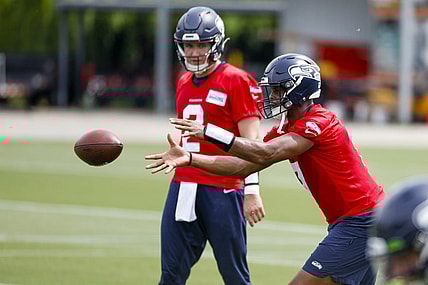 Jun 7, 2022; Renton, Washington, USA; Seattle Seahawks quarterback Geno Smith (7) receives a shotgun snap in front of quarterback Drew Lock (2) during minicamp practice at the Virginia Mason Athletic Center Field. Mandatory Credit: Joe Nicholson-USA TODAY Sports