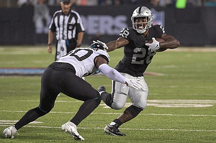 Aug 4, 2022; Canton, Ohio, USA; Las Vegas Raiders running back Josh Jacobs (28) runs against Jacksonville Jaguars linebacker Shaquille Quarterman (50) in the first quarter at Tom Benson Hall of Fame Stadium. Mandatory Credit: Ken Blaze-USA TODAY Sports