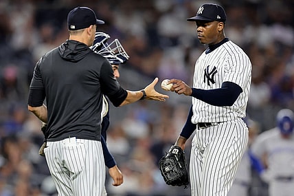 Aug 19, 2022; Bronx, New York, USA; New York Yankees relief pitcher Aroldis Chapman (54) hands the ball to manager Aaron Boone (17) after being taken out of the game against the Toronto Blue Jays during the ninth inning at Yankee Stadium. Mandatory Credit: Brad Penner-USA TODAY Sports
