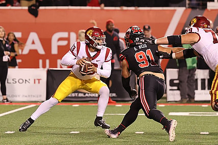 Oct 15, 2022; Salt Lake City, Utah, USA; USC Trojans quarterback Caleb Williams (13) scrambles away from the pressure of Utah Utes defensive end Gabe Reid (91) in the second quarter at Rice-Eccles Stadium. Mandatory Credit: Rob Gray-USA TODAY Sports