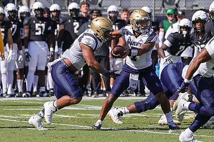 Nov 19, 2022; Orlando, Florida, USA; Navy Midshipmen quarterback Xavier Arline (7) hands off to Navy Midshipmen fullback Daba Fofana (45) during the first quarter at FBC Mortgage Stadium. Mandatory Credit: Mike Watters-USA TODAY Sports