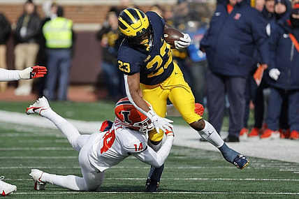 Nov 19, 2022; Ann Arbor, Michigan, USA;  Michigan Wolverines running back C.J. Stokes (23) is tackled by Illinois Fighting Illini defensive back Xavier Scott (14) in the first half at Michigan Stadium. Mandatory Credit: Rick Osentoski-USA TODAY Sports
