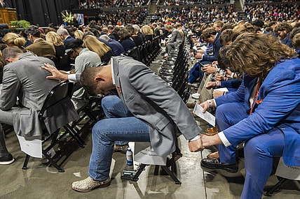 Nov 19, 2022; Charlottesville, Virginia, US; A general view as members of the Virginia Cavaliers football team pray during the memorial service for three slain University of Virginia football players Lavel Davis Jr., D Sean Perry and Devin Chandler at John Paul Jones Arena. Mandatory Credit: Erin Edgerton/Pool Photo-USA TODAY Sports