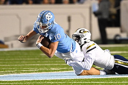 Nov 19, 2022; Chapel Hill, North Carolina, USA; North Carolina Tar Heels quarterback Drake Maye (10) is tackled by Georgia Tech Yellow Jackets linebacker Charlie Thomas (1) in the first quarter at Kenan Memorial Stadium. Mandatory Credit: Bob Donnan-USA TODAY Sports