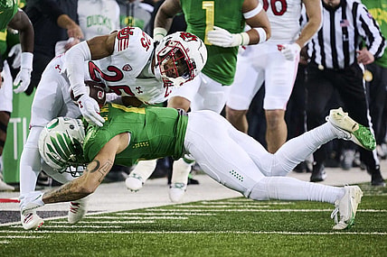Nov 19, 2022; Eugene, Oregon, USA; Oregon Ducks defensive back Bennett Williams (4) tackles Utah Utes wide receiver Jaylen Dixon (25) during the first half at Autzen Stadium. Mandatory Credit: Troy Wayrynen-USA TODAY Sports