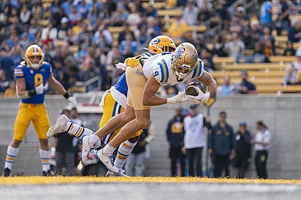 November 25, 2022; Berkeley, California, USA; UCLA Bruins wide receiver Jake Bobo (9) scores a touchdown against California Golden Bears safety Craig Woodson (2) during the first quarter at California Memorial Stadium. Mandatory Credit: Kyle Terada-USA TODAY Sports