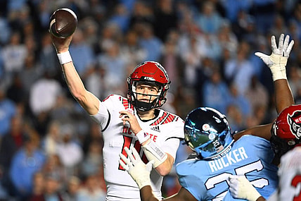 Nov 25, 2022; Chapel Hill, North Carolina, USA; North Carolina State Wolfpack quarterback Ben Finley (10) passes the ball as North Carolina Tar Heels defensive lineman Kaimon Rucker (25) defends in the fourth quarter at Kenan Memorial Stadium. Mandatory Credit: Bob Donnan-USA TODAY Sports