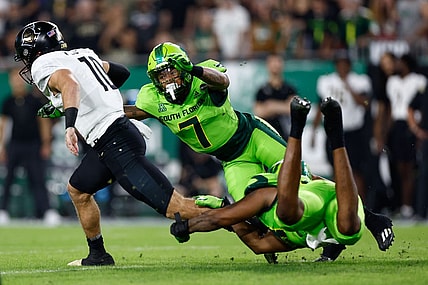 Nov 26, 2022; Tampa, Florida, USA; UCF Knights quarterback John Rhys Plume (10) scrambles with the ball as South Florida Bulls safety Will Jones II (7) defends during the first quarter at Raymond James Stadium. Mandatory Credit: Douglas DeFelice-USA TODAY Sports