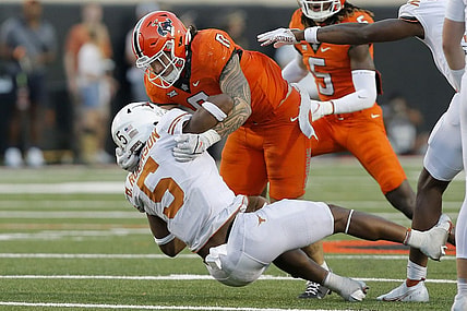 Oct 22, 2022; Stillwater, Oklahoma, USA;  Oklahoma State Cowboys linebacker Mason Cobb (0) brings down Texas Longhorns running back Bijan Robinson (5) during a game at Boone Pickens Stadium. Mandatory Credit: Bryan Terry/The Oklahoman via USA TODAY NETWORK