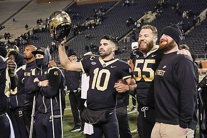 Nov 19, 2022; Winston-Salem, North Carolina, USA;  Wake Forest Demon Deacons quarterback Sam Hartman (10) holds up his helmet during the singing of the school alma mater after the win against the Syracuse Orange at Truist Field. Mandatory Credit: Jim Dedmon-USA TODAY Sports