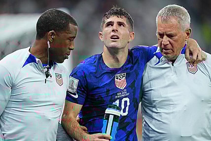 Nov 29, 2022; Doha, Qatar; United States of America forward Christian Pulisic (10) is helped after sustaining an injury after colliding with Iran goalkeeper Alireza Beiranvand (1) following his goal during the first half of a group stage match during the 2022 World Cup at Al Thumama Stadium. Mandatory Credit: Danielle Parhizkaran-USA TODAY Sports