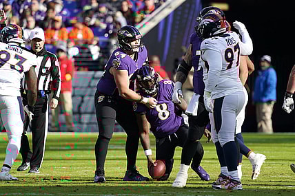 Dec 4, 2022; Baltimore, Maryland, USA; Baltimore Ravens quarterback Lamar Jackson (8) is helped to his feet by center Tyler Linderbaum (64) after being sacked by the Denver Broncos at M&T Bank Stadium. Mandatory Credit: Mitch Stringer-USA TODAY Sports