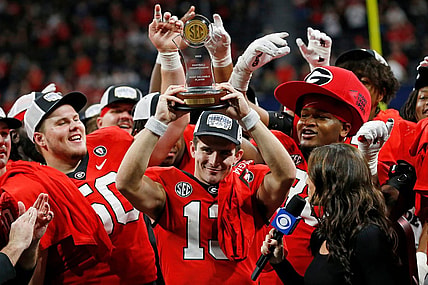 Georgia quarterback Stetson Bennett (13) raises the SEC Championship MVP trophy after the SEC Championship NCAA college football game between LSU and Georgia in Atlanta, on Saturday, Dec. 3, 2022. Georgia won 50-30.

News Joshua L Jones