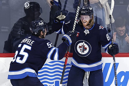 Dec 15, 2022; Winnipeg, Manitoba, CAN; Winnipeg Jets center Mark Scheifele (55) celebrates the overtime goal by Winnipeg Jets left wing Kyle Connor (81) against the Nashville Predators at Canada Life Centre. Mandatory Credit: James Carey Lauder-USA TODAY Sports