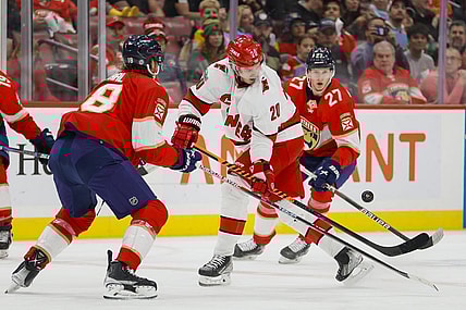 Apr 13, 2023; Sunrise, Florida, USA; Carolina Hurricanes center Sebastian Aho (20) controls the puck against Florida Panthers defenseman Marc Staal (18) and center Eetu Luostarinen (27) during the first period at FLA Live Arena. Mandatory Credit: Sam Navarro-USA TODAY Sports