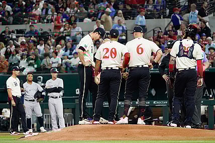 Apr 28, 2023; Arlington, Texas, USA; Texas Rangers starting pitcher Jacob deGrom (48) is visited on the mound by teammates and pitching coach pitching coach Mike Maddux (31) before leaving the game in the fourth inning against the New York Yankees at Globe Life Field. Mandatory Credit: Raymond Carlin III-USA TODAY Sports