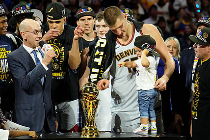 Jun 12, 2023; Denver, Colorado, USA; Denver Nuggets center Nikola Jokic (15) and his daughter point to the Bill Russell NBA Finals MVP Award trophy after winning the 2023 NBA Finals against the Miami Heat at Ball Arena. Mandatory Credit: Kyle Terada-USA TODAY Sports
