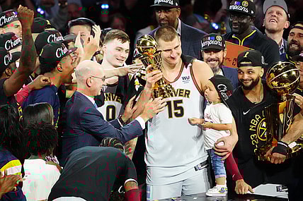 Jun 12, 2023; Denver, Colorado, USA; NBA commissioner Adam Silver presents the Bill Russell NBA Finals MVP Award to Denver Nuggets center Nikola Jokic (15) as Jokic holds his daughter Ognjena Jokic after the Nuggets won the 2023 NBA Championship against the Miami Heat at Ball Arena. Looking on is Denver guard Jamal Murray (27) holds the Larry O'Brien Trophy. Mandatory Credit: Ron Chenoy-USA TODAY Sports