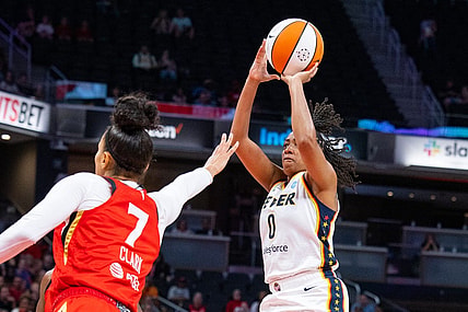 Jun 4, 2023; Indianapolis, Indiana, USA; Indiana Fever guard Kelsey Mitchell (0) shoots the ball while Las Vegas Aces forward Alysha Clark (7) defends in the first half at Gainbridge Fieldhouse. Mandatory Credit: Trevor Ruszkowski-USA TODAY Sports