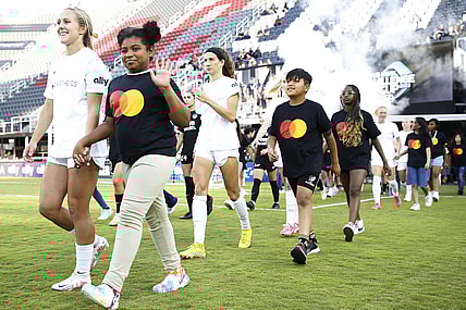 Jun 14, 2023; Washington, D.C., USA; Young fans walk with the North Carolina Courage  before ether match against the Washington Spirit at Audi Field. Mandatory Credit: Amber Searls-USA TODAY Sports